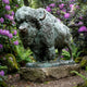 Life-Size Traditional Bison Bronze Sculpture by Giant Sculptures with verdigris patina, displayed on a stone plinth among ferns and purple rhododendrons.