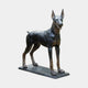 Life-Size Traditional Doberman Pinscher Bronze Sculpture by Giant Sculptures, standing four-square on a flat base with dark patina and warm bronze highlights.