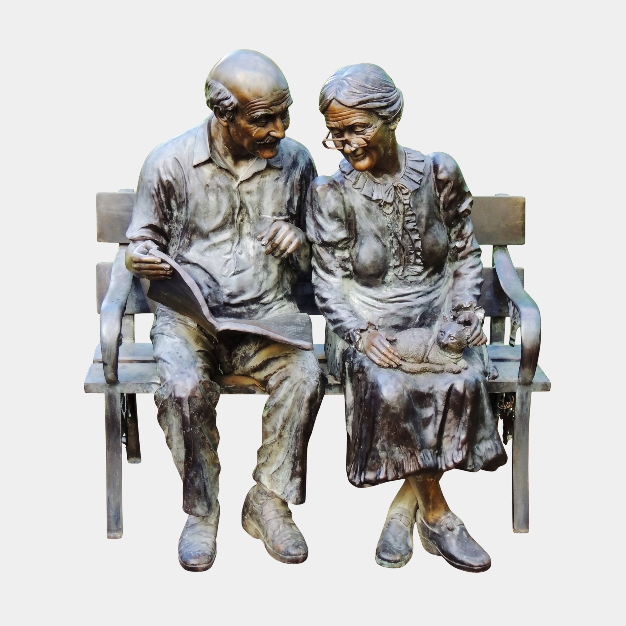 Life-Size Traditional Elderly Couple on Bench Bronze Sculpture by Giant Sculptures, man holding an open book beside a woman with a cat in her lap.