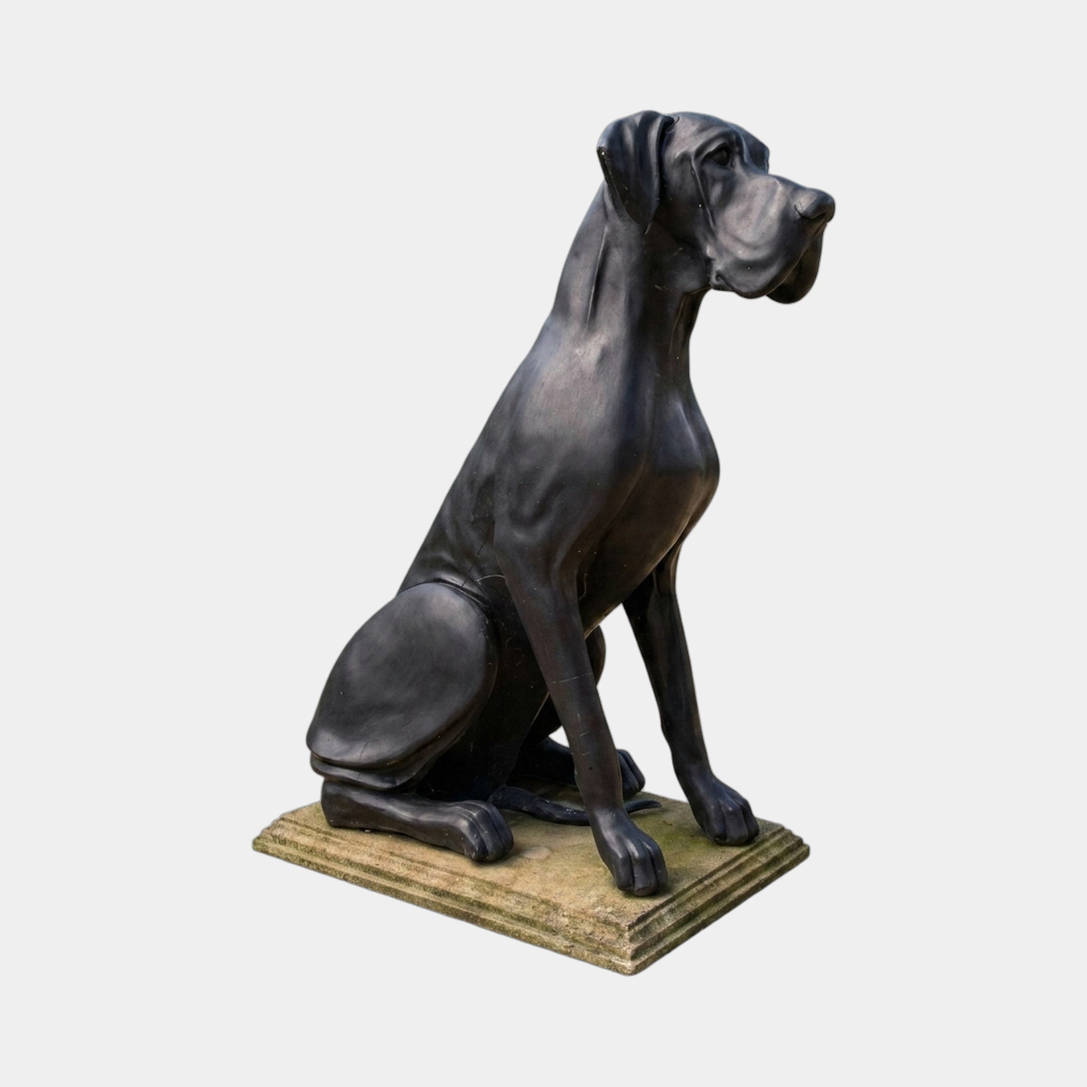 Life-Size Traditional Great Dane Dog Bronze Sculpture by Giant Sculptures in dark patina, seated upright in three-quarter profile on a pale stone base.