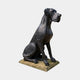 Life-Size Traditional Great Dane Dog Bronze Sculpture by Giant Sculptures in dark patina, seated upright in three-quarter profile on a pale stone base.