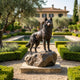 Life-Size Traditional Husky Dog Bronze Sculpture by Giant Sculptures with dark patina on a rock base, displayed in a formal garden with lavender and pool.