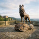 Life-Size Traditional Husky Dog Bronze Sculpture by Giant Sculptures, standing alert on a rugged rock base atop a balustraded terrace overlooking a country estate.