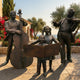 Life-Size Traditional Musician Ensemble Bronze Sculpture by Giant Sculptures with double bassist, violinist, and two singing children on a sunlit stone terrace.