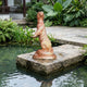 Life-Size Traditional Rearing Otter Bronze Sculpture by Giant Sculptures with warm copper patina, displayed on a stone slab beside a garden pond.