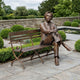 Life-Size Traditional Seated Male Figure Bronze Sculpture by Giant Sculptures, 170cm, shown on a paved garden terrace beside topiary and a lily pond.