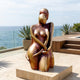 Modern Abstract Female Figure Bronze Sculpture by Giant Sculptures on a stone plinth, displayed on an oceanfront terrace with agave planters and timber steps.