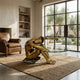 Modern Seated Nude Female Figure Bronze Sculpture by Giant Sculptures used as a coffee table base with oval glass top in a sunlit room with leather armchair.
