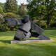 Monumental Abstract Martial Arts Figure Bronze Sculpture by Giant Sculptures in charcoal patina, lunging pose on a concrete plinth in a garden lawn setting.