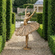 Monumental Classical Ballerina Dancer Bronze Sculpture by Giant Sculptures in golden-bronze finish, posed en pointe with arms raised, on a gravel garden path.