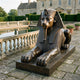 Monumental Classical Egyptian Sphinx Bronze Sculpture by Giant Sculptures, recumbent figure with nemes headdress and warm brown patina, beside a formal estate pool.