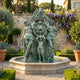 Monumental Classical Goddesses with Child and Lion Medallion Bronze Fountain by Giant Sculptures, verdigris patina, in a Mediterranean garden with lavender and wisteria.
