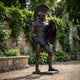 Giant Sculptures Monumental Classical Greek Warrior Bronze Statue 250cm in dark patina, striding with shield and sword, displayed in a garden beside ivy-covered stone walls.