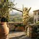 Giant Sculptures Monumental Classical Herald Angel Bronze Sculpture in gilt finish, wings spread and trumpet raised, on a Tuscan terrace overlooking vineyards.