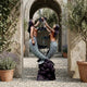 Monumental Classical Intertwined Mermaids Bronze Fountain by Giant Sculptures, 350cm, displayed in a stone courtyard archway with potted lavender and olive trees.