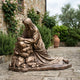 Monumental Classical Kneeling Christ in Prayer Bronze Sculpture by Giant Sculptures, robed figure kneeling at a rock on a stone courtyard beside roses.
