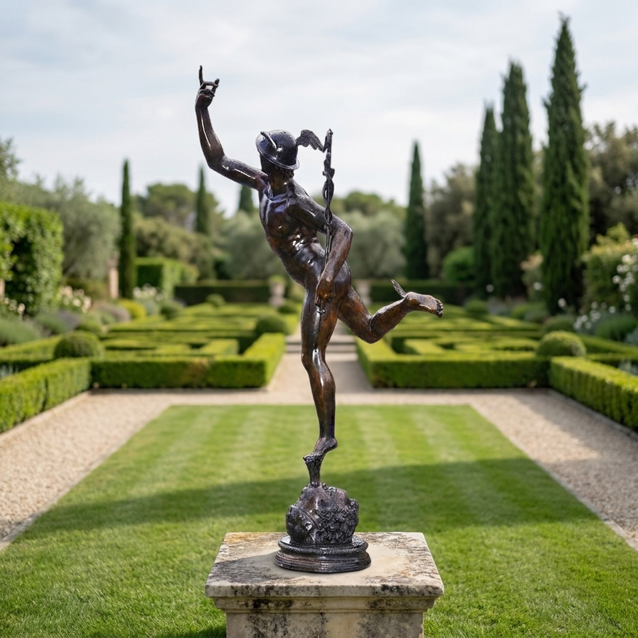 Monumental Classical Mercury Bronze Sculpture by Giant Sculptures shown in full stride on a stone plinth at the end of a formal hedged garden.