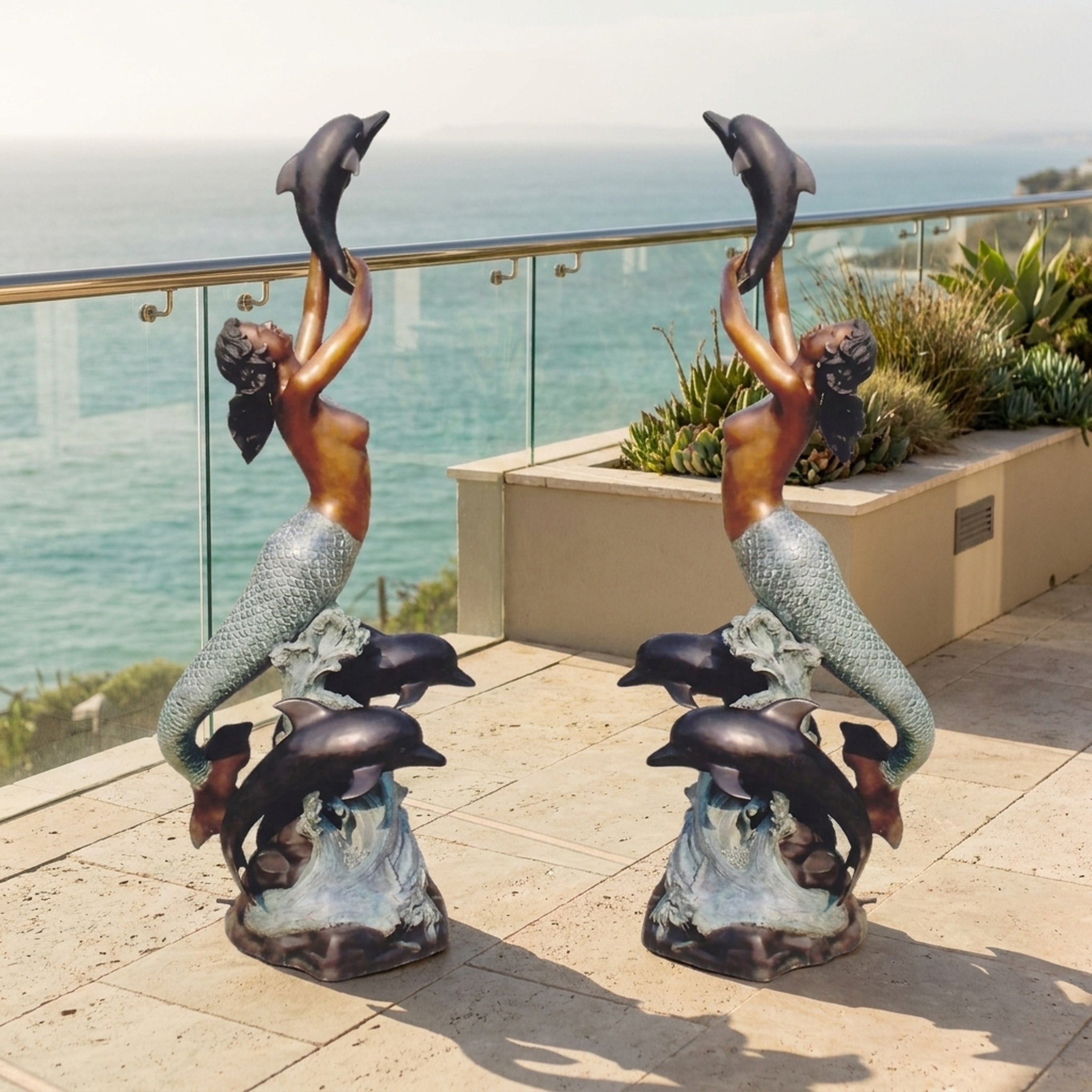 Pair of Giant Sculptures Monumental Classical Mermaid and Dolphin Bronze Sculptures on a seaside terrace, mermaids arching upward to lift leaping dolphins.