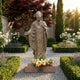 Monumental Classical Papal Figure Bronze Statue by Giant Sculptures, 250cm, holding a ferula cross in a formal garden with hedges, lavender, and white roses.
