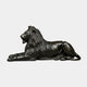Monumental Classical Recumbent Lion Bronze Sculpture by Giant Sculptures in dark patina, shown in side profile with raised head and open-mouthed roar on plain background.