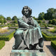 Monumental Classical Seated Male Figure Bronze Sculpture by Giant Sculptures, 400cm, verdigris patina, shown seated in contemplation in a formal lavender garden.