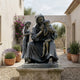 Monumental Classical Seated Robed Figure with Children Bronze Sculpture by Giant Sculptures displayed on a stone plinth in a Mediterranean courtyard.