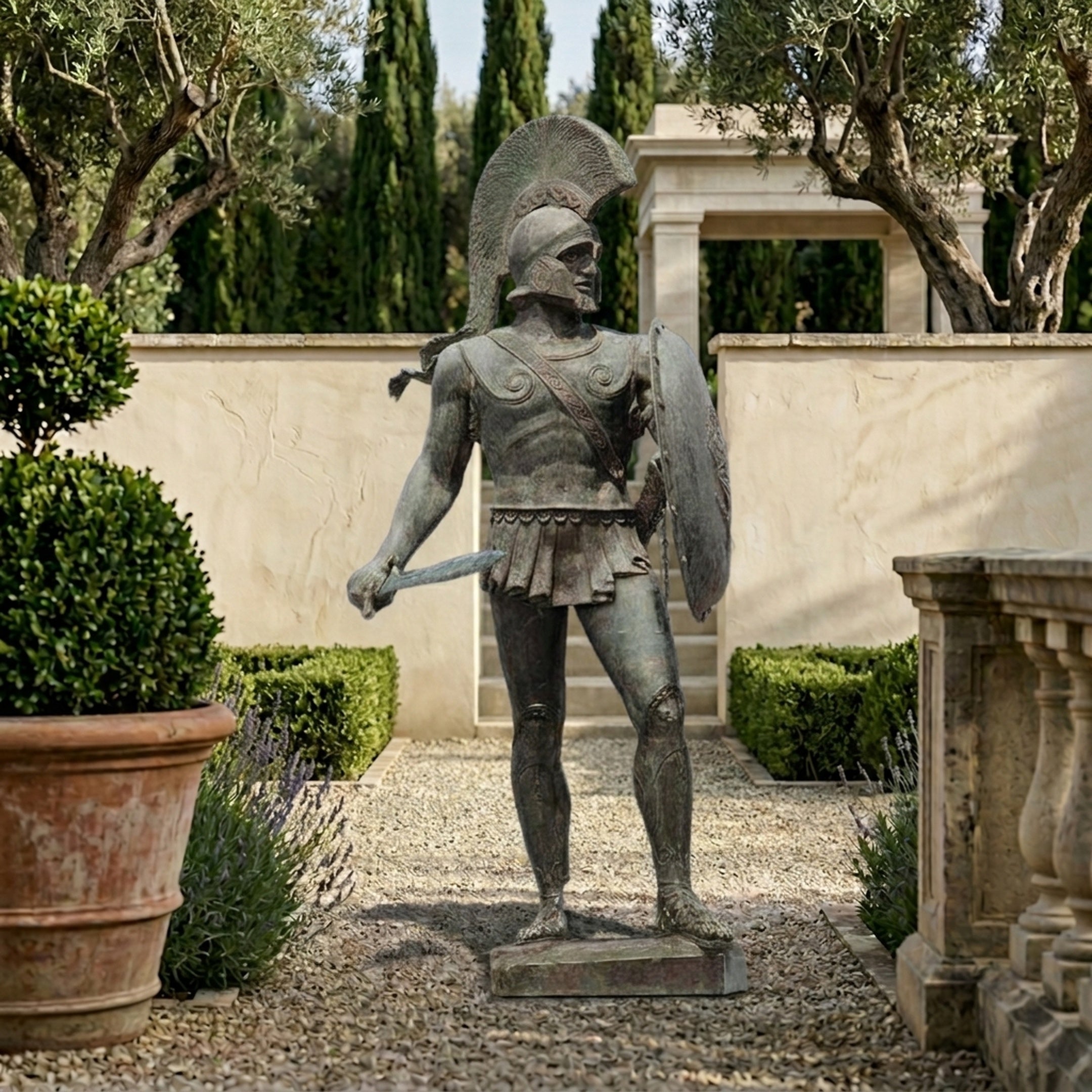 Monumental Classical Spartan Warrior Bronze Statue by Giant Sculptures with verdigris patina, crested helmet, shield and sword, in a Mediterranean garden courtyard.