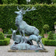 Monumental Classical Stag Doe and Fawn Bronze Sculpture by Giant Sculptures with verdigris patina, displayed on a gravel path before a tall green hedge.