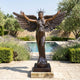 Giant Sculptures' 250cm Monumental Classical Standing Angel Bronze Sculpture with spread wings, raised arms and spiked crown, on a square base beside a garden pool.
