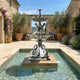 Giant Sculptures Monumental Classical Swan and Cherub Bronze Fountain in verdigris patina, set in a rectangular pool within a sunlit Mediterranean courtyard.