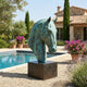Monumental Contemporary Abstract Horse Head Bronze Sculpture by Giant Sculptures with verdigris patina on a dark plinth beside a poolside Mediterranean villa.