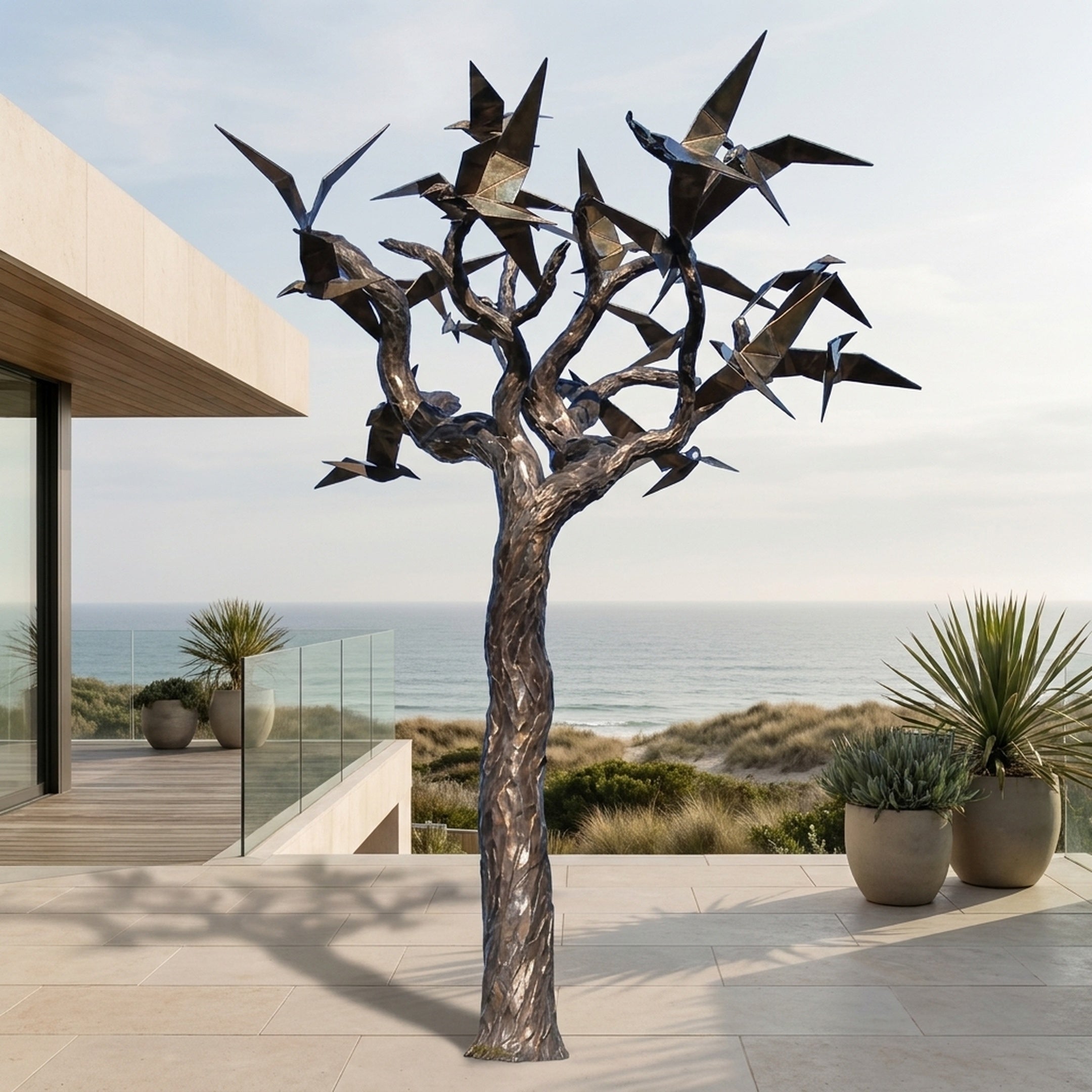 Monumental Contemporary Bird and Tree Bronze Sculpture by Giant Sculptures on a seaside terrace, with angular birds in flight across a textured branching trunk.