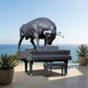 Monumental Contemporary Bull atop Grand Piano Bronze Sculpture by Giant Sculptures in matte black with silver-grey horns, displayed on an oceanview terrace.