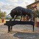 Monumental Contemporary Charging Bull on Grand Piano Bronze Sculpture by Giant Sculptures in matte black, displayed on a stone terrace beside a pool.