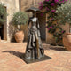 Monumental Contemporary Elongated Female Figure Bronze Sculpture by Giant Sculptures in dark patina, displayed in a Mediterranean courtyard with bougainvillea.
