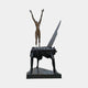 Monumental Contemporary Figure on Grand Piano Bronze Sculpture by Giant Sculptures, brown nude with raised arms atop a black piano on tall spindly legs.