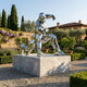 Monumental Contemporary Geometric Sprinting Figure Bronze Sculpture by Giant Sculptures in mirror-polished facets on a marble plinth in a Tuscan garden.