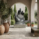 Monumental Contemporary Open Hand Bronze Sculpture by Giant Sculptures, palm raised on a stone plinth in an arched courtyard with olive trees and lavender.