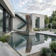Giant Sculptures' 250cm Monumental Contemporary Oversized Human Thumb Bronze Sculpture displayed upright on a concrete plinth above a reflecting pool in a modern courtyard.