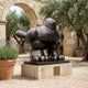Monumental Contemporary Rotund Pigeon Bronze Sculpture by Giant Sculptures, dark patina finish on a stone plinth in a Mediterranean courtyard with olive trees.