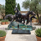 Giant Sculptures Monumental Contemporary Running Horses Bronze Sculpture 280cm, four galloping horses bursting from a graffitied Berlin Wall base in a garden courtyard.