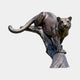 Monumental Crouching Cougar Bronze Sculpture by Giant Sculptures, 320cm, shown in dark brown patina crouched on a tree stump base against a plain background.