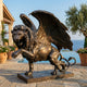 Monumental Heraldic Winged Lion Bronze Sculpture by Giant Sculptures, rearing and roaring with wings raised, on a granite plinth beside a clifftop pool.