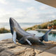 Monumental Humpback Whale and Calf Bronze Sculpture by Giant Sculptures on a stone terrace beside a pool, with beach, ocean and succulents behind.