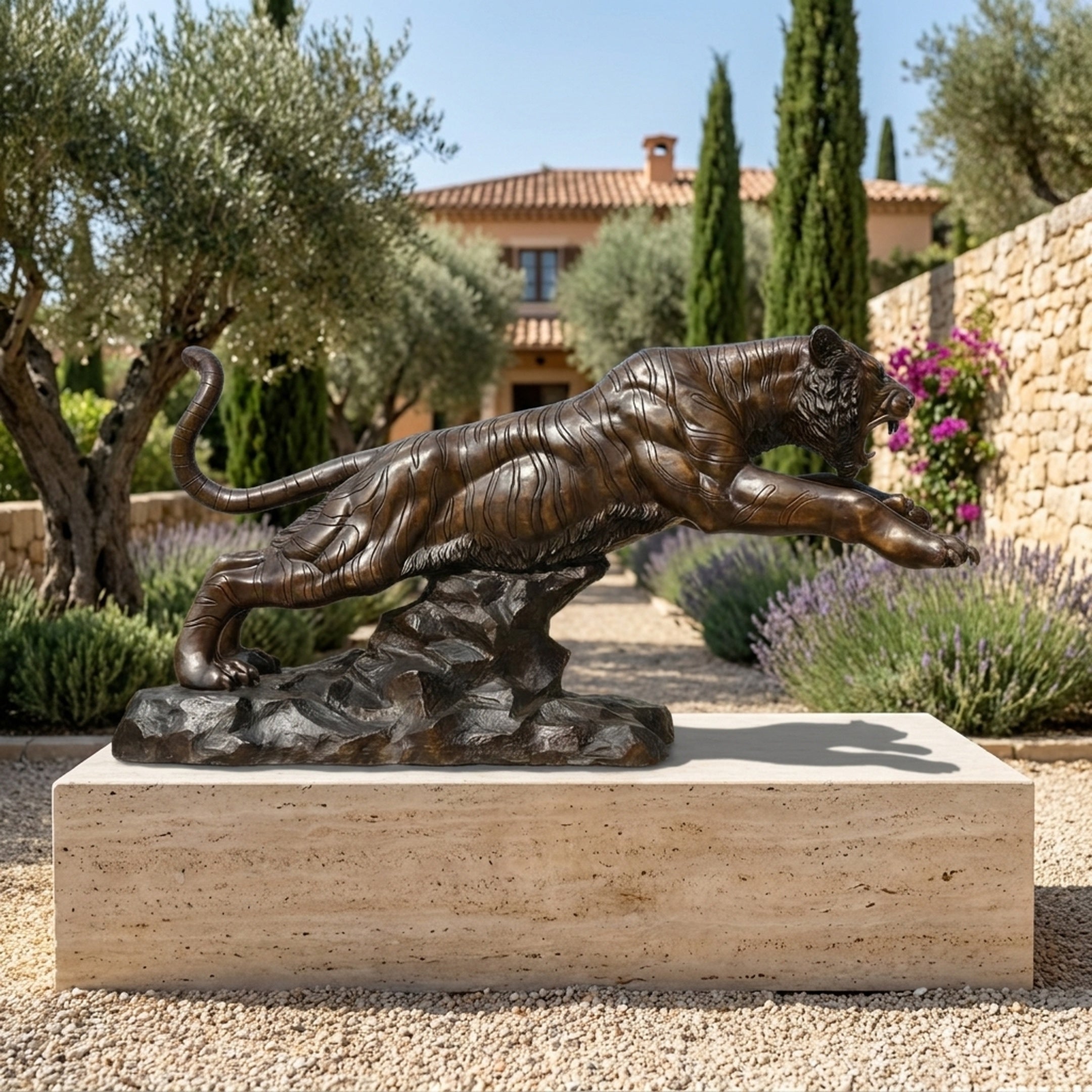 Monumental Life-Size Leaping Tiger Bronze Sculpture by Giant Sculptures on a travertine plinth in a Mediterranean garden with lavender and cypress trees.