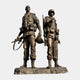 Monumental Military Soldiers Bronze Sculpture by Giant Sculptures, 300cm dark bronze double figure of two soldiers in combat gear on a rocky base.