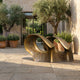 Monumental Modern Abstract Arch Bronze Sculpture by Giant Sculptures with golden-brown patina, displayed on a stone courtyard with olive trees and lavender.
