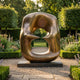 Monumental Modern Abstract Biomorphic Bronze Sculpture by Giant Sculptures, 340cm, with interlocking lobes and central void on a dark plinth in a formal garden.