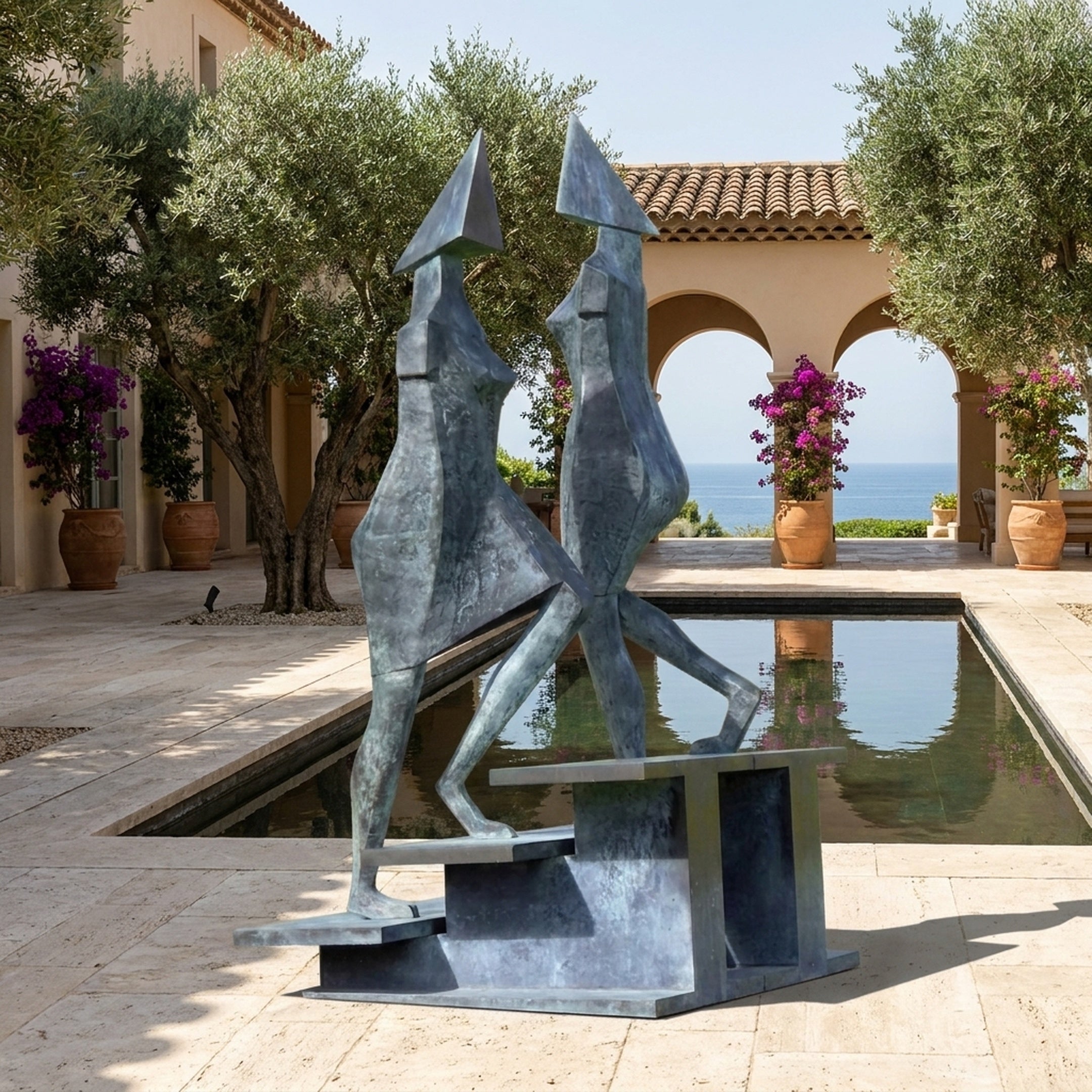 Monumental Modern Abstract Duo Bronze Sculpture by Giant Sculptures, two angular figures with conical heads on a stepped plinth beside a reflecting pool overlooking the sea.