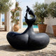 Monumental Modern Abstract Mother and Infant Bronze Sculpture by Giant Sculptures in near-black patina, displayed on a stone patio beside a pool and olive trees.